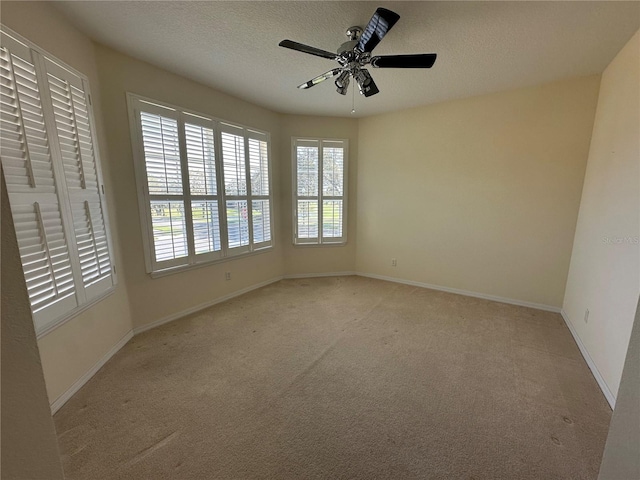 carpeted spare room featuring a textured ceiling and ceiling fan