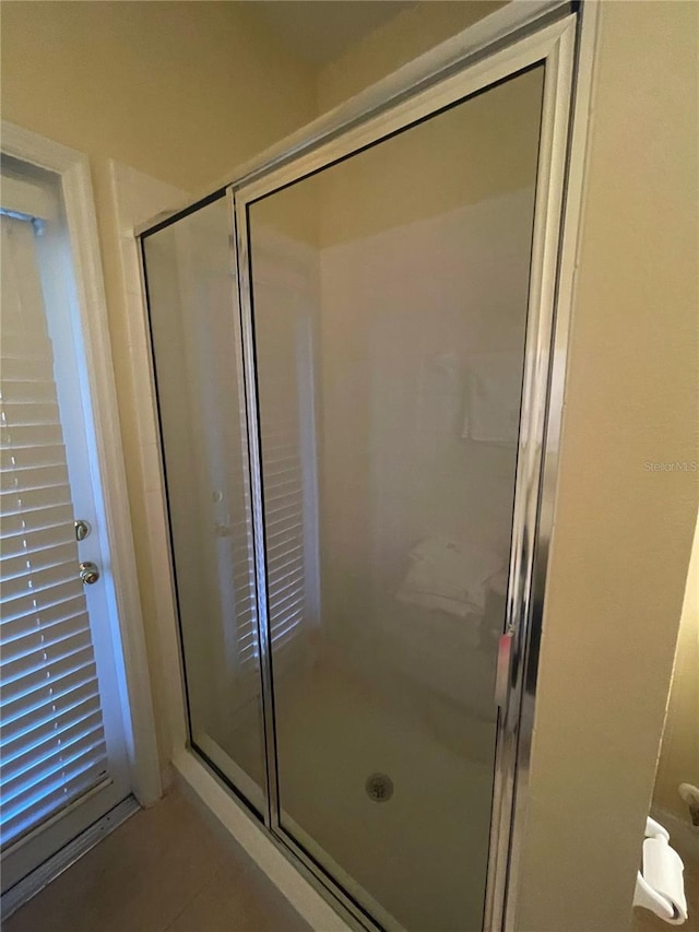 bathroom featuring a shower with shower door and tile patterned flooring