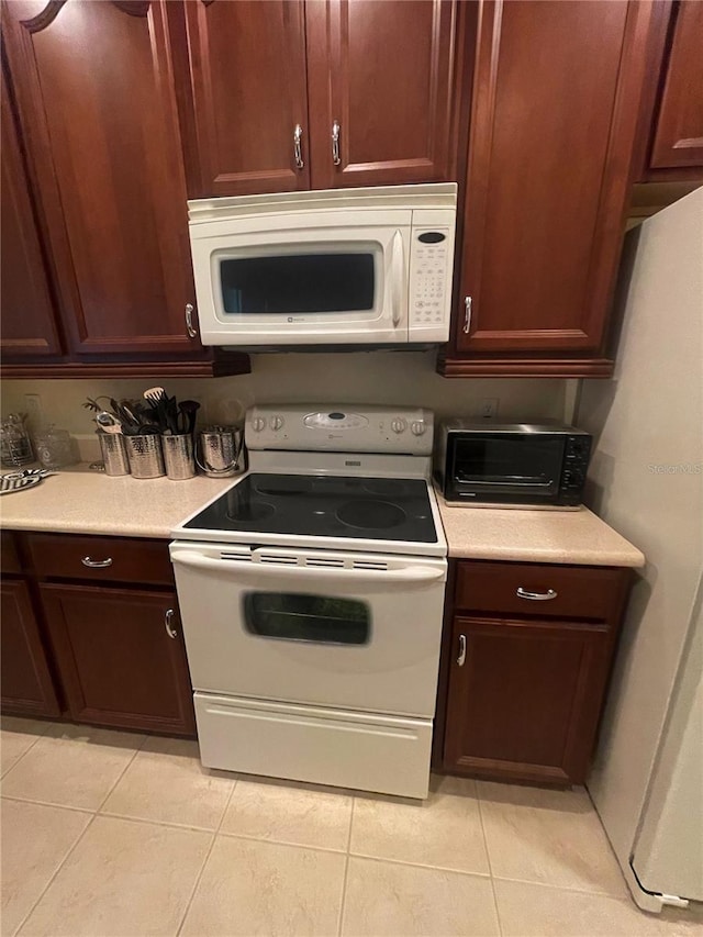 kitchen with light tile patterned floors and white appliances