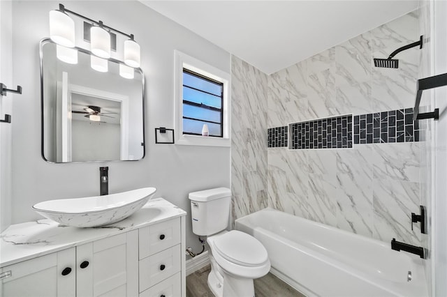 full bathroom featuring ceiling fan, tiled shower / bath, vanity, toilet, and hardwood / wood-style floors