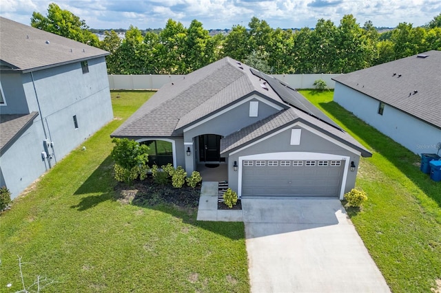 220 Bergamot Loop, Davenport, FL 33837 - view of front facade with an attached garage, concrete driveway, roof with shingles, stucco siding, and solar panels