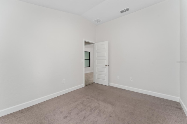 carpeted spare room featuring lofted ceiling