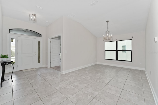 entrance foyer with lofted ceiling, an inviting chandelier, and light tile patterned floors