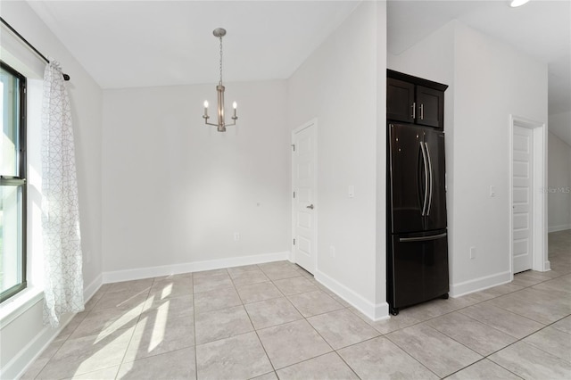 unfurnished dining area featuring an inviting chandelier, lofted ceiling, light tile patterned flooring, and a healthy amount of sunlight