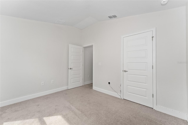 carpeted empty room with lofted ceiling