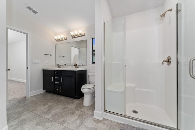 bathroom with tile patterned floors, a shower with door, vanity, and toilet