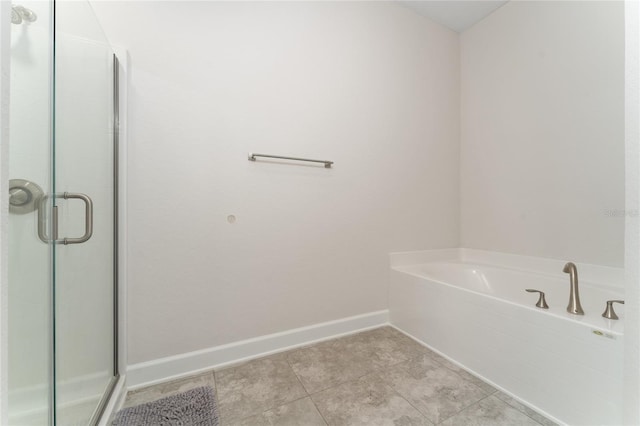 220 Bergamot Loop, Davenport, FL 33837 - bathroom featuring a stall shower, a garden tub, baseboards, and tile patterned floors