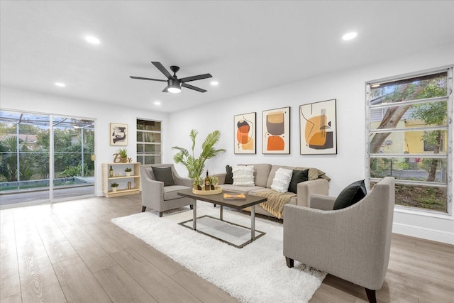 living room featuring wood-type flooring and ceiling fan