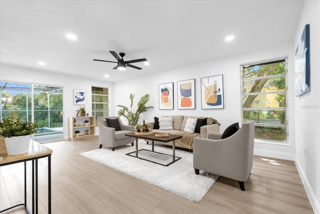 living room featuring light wood-type flooring and ceiling fan