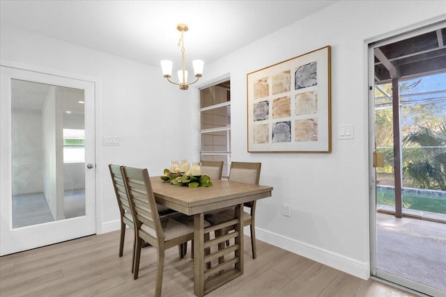 dining space featuring a notable chandelier and light wood-type flooring