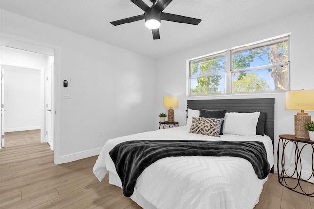 bedroom with light hardwood / wood-style floors and ceiling fan