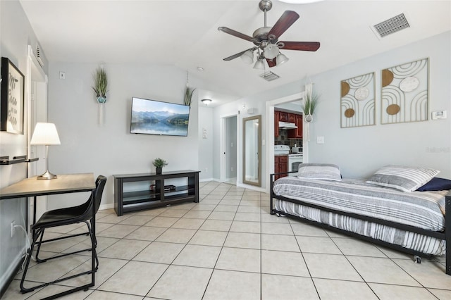 bedroom with ceiling fan, light tile patterned floors, and vaulted ceiling