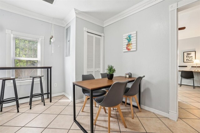 tiled dining room featuring a baseboard radiator and crown molding