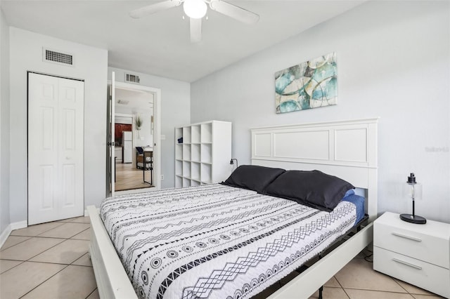 tiled bedroom featuring ceiling fan, white refrigerator, and a closet