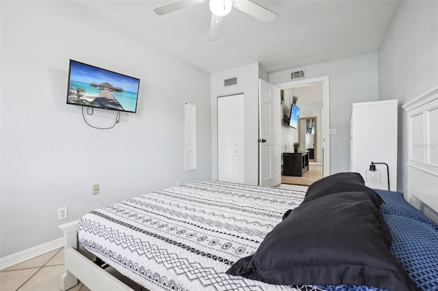 tiled bedroom with ceiling fan and a closet