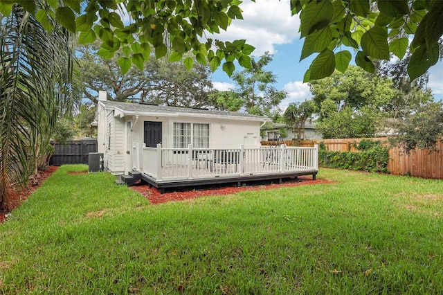 back of property with a lawn, a deck, and central AC unit