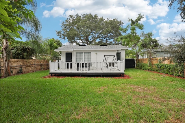 back of house featuring a wooden deck and a yard