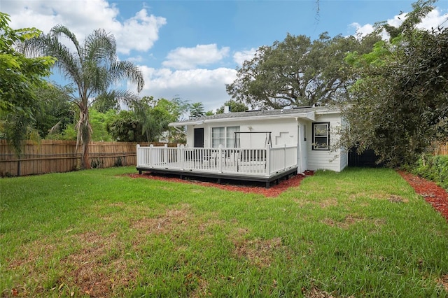 back of house featuring a deck and a yard