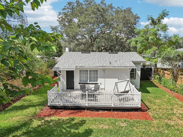 rear view of property featuring a deck and a yard