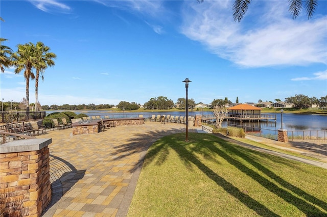 view of home's community with a water view and a lawn