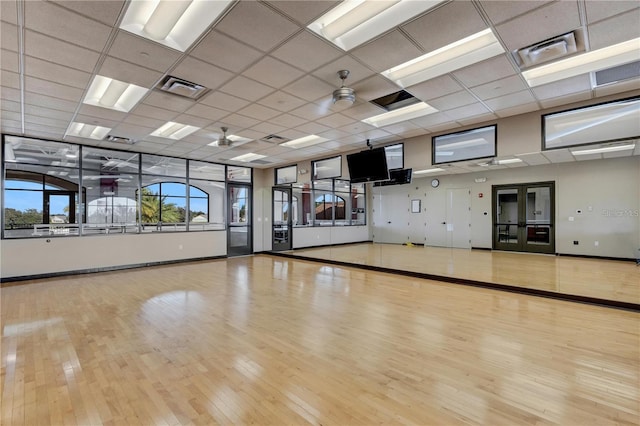 workout area with visible vents, wood finished floors, and baseboards