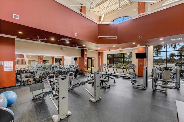 workout area with ceiling fan and a towering ceiling