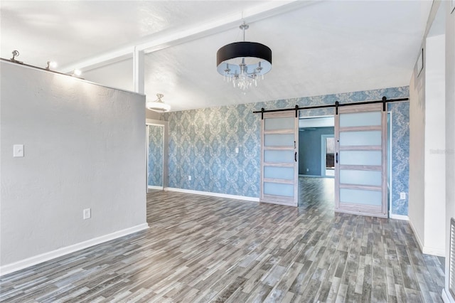 unfurnished living room with vaulted ceiling with beams, hardwood / wood-style floors, and a barn door