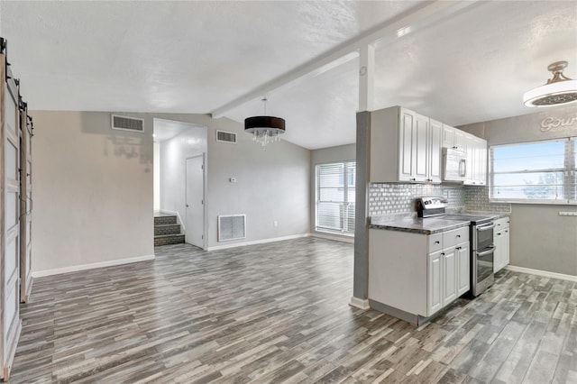 kitchen with lofted ceiling with beams, stainless steel electric range, and hardwood / wood-style flooring