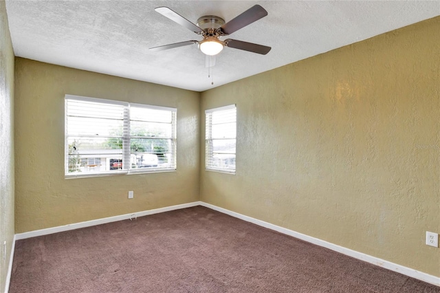 carpeted spare room featuring ceiling fan and a textured ceiling