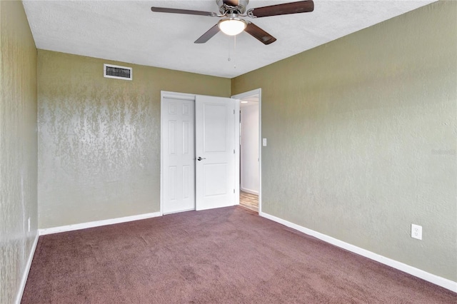 unfurnished bedroom with ceiling fan, carpet flooring, and a textured ceiling