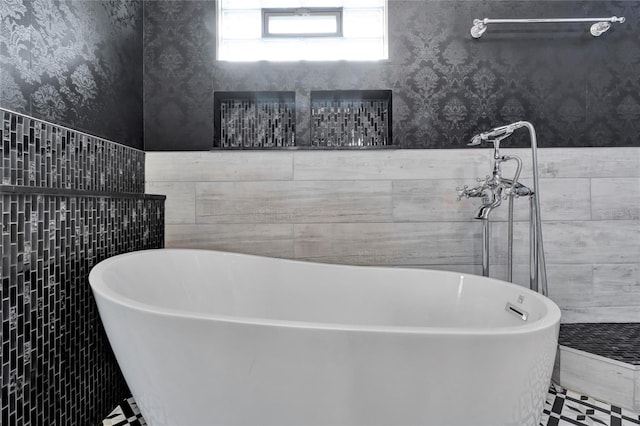 bathroom with tile walls and a tub to relax in