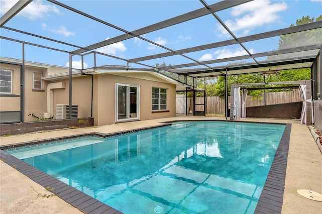 view of pool featuring glass enclosure and a patio