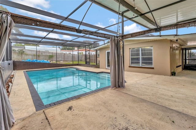 view of swimming pool featuring glass enclosure and a patio area