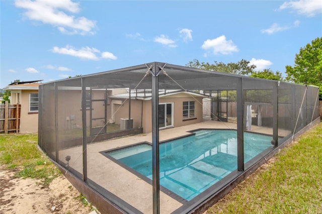 view of swimming pool with glass enclosure and a patio area