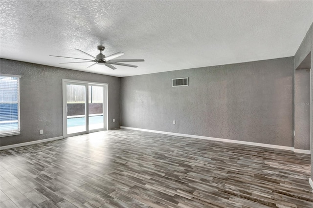 spare room with ceiling fan, a textured ceiling, and dark hardwood / wood-style floors