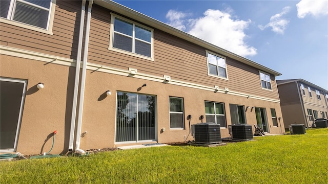 rear view of property with a yard and central AC