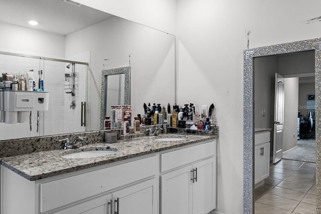 bathroom featuring tile patterned flooring, vanity, and a shower with shower door