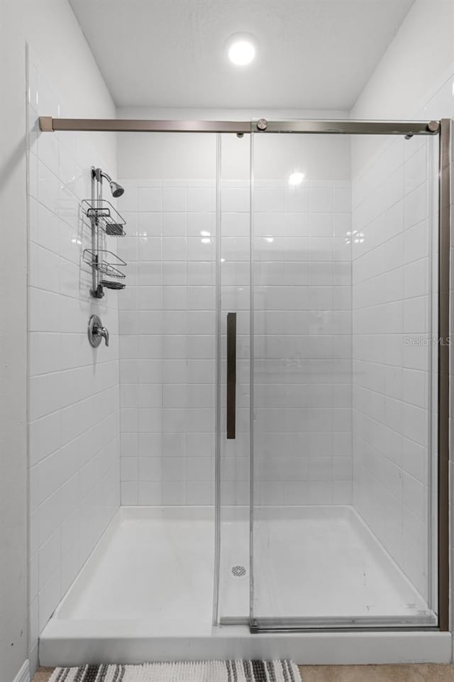 bathroom featuring a shower with shower door