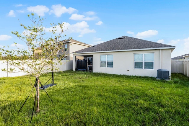 rear view of property with a yard and central AC unit