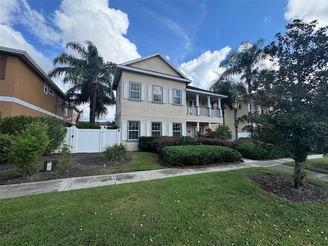 view of front facade with a balcony and a front lawn