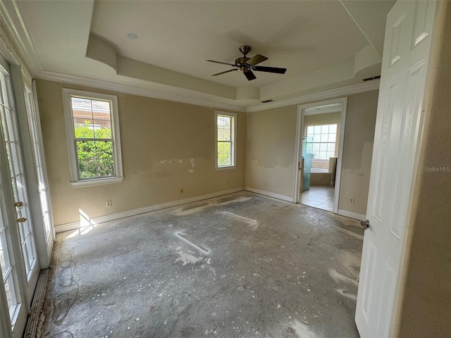 unfurnished room with ornamental molding, ceiling fan, a raised ceiling, and a healthy amount of sunlight