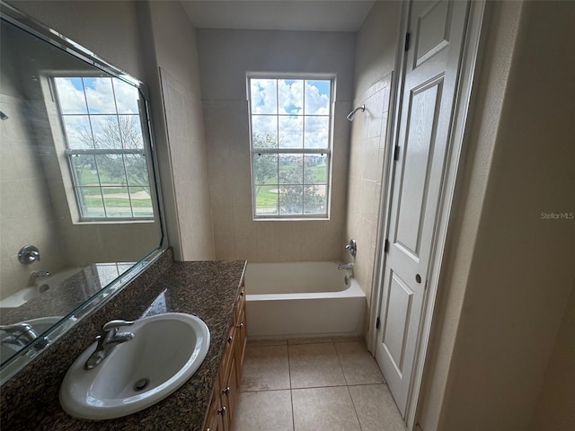 bathroom with tile patterned floors, vanity, tiled shower / bath combo, and a healthy amount of sunlight