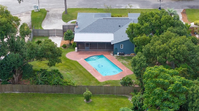 view of pool with a fenced in pool, a yard, a patio, a sunroom, and a fenced backyard