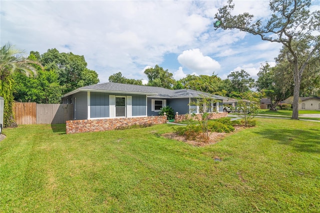 back of property featuring fence and a lawn