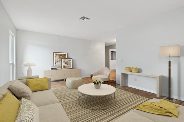 living room with baseboards, visible vents, and wood finished floors