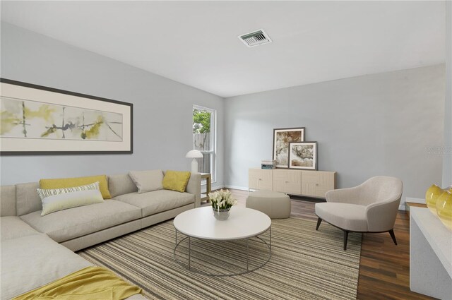 living room with wood finished floors, visible vents, and baseboards