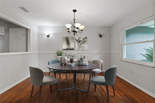 dining space with a notable chandelier, wood finished floors, visible vents, and baseboards