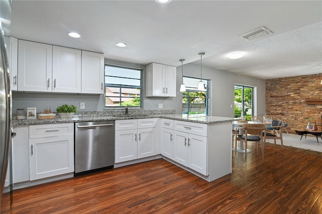 kitchen featuring visible vents, stainless steel dishwasher, dark wood-type flooring, a sink, and a peninsula