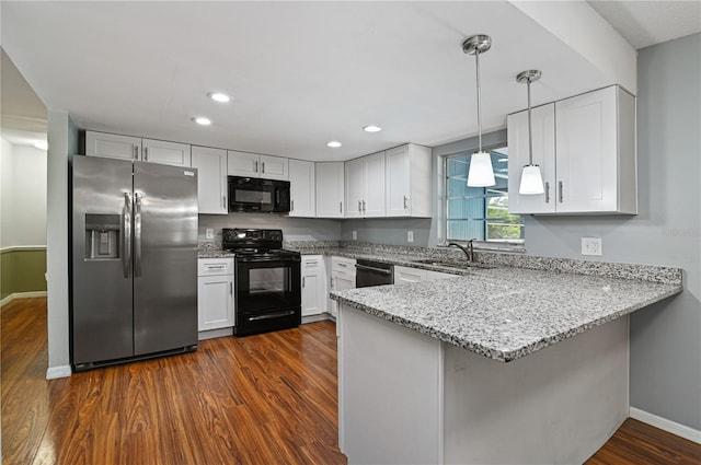 kitchen featuring a peninsula, a sink, light stone countertops, dark wood-style floors, and black appliances