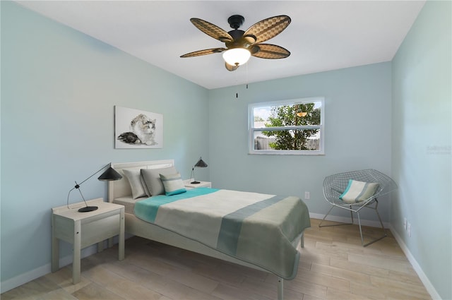 bedroom with light wood finished floors, baseboards, and a ceiling fan